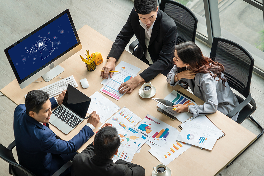 Profissionais avaliam gráficos que ilustram a diferença entre inteligência artificial e machine learning na tomada de decisões. 